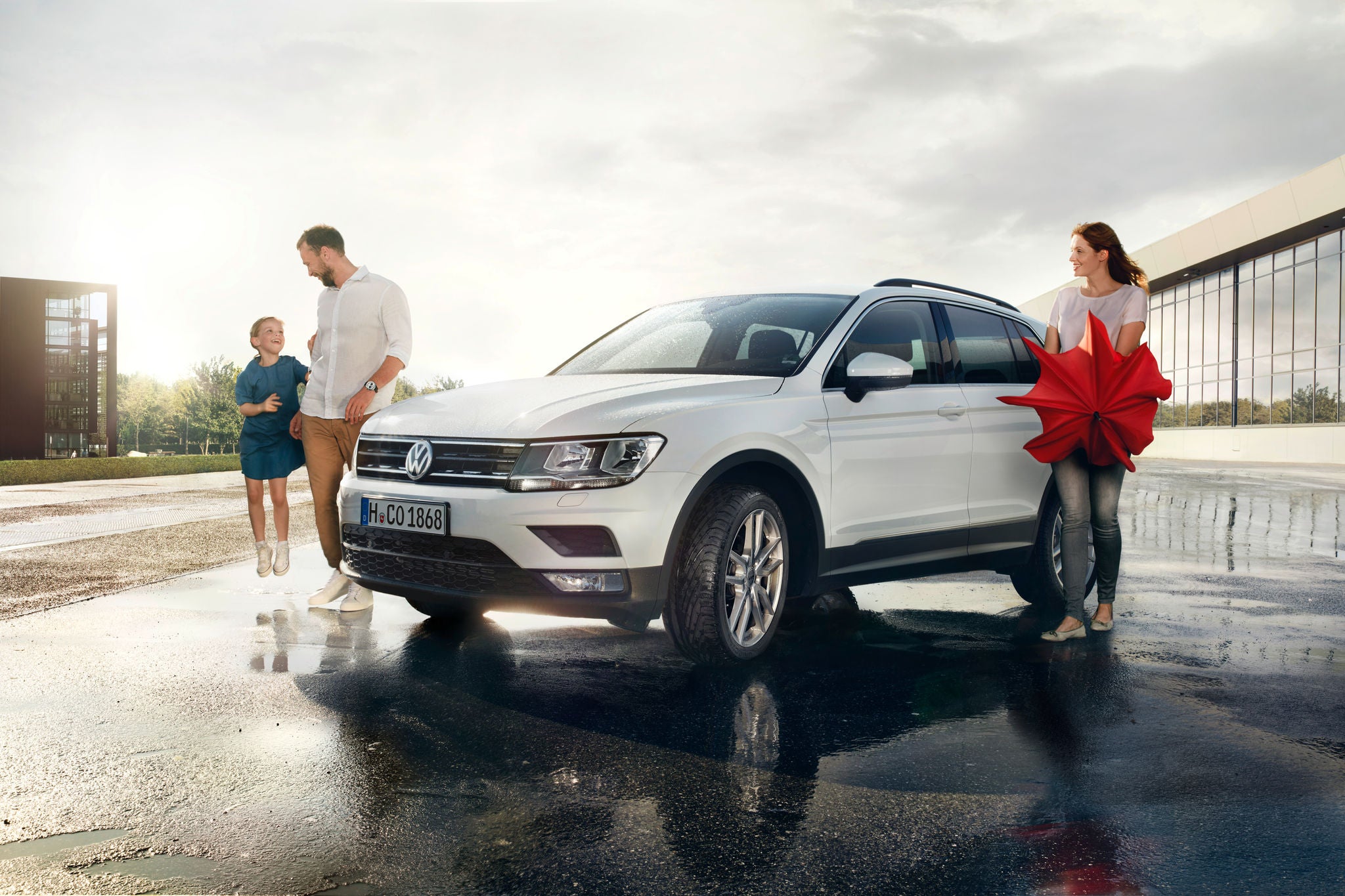 Parents and daughter next to white SUV equipped with Uniroyal RainSport 3 tyres