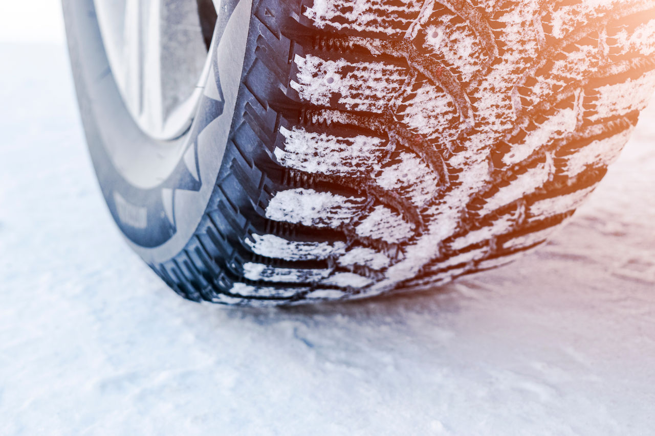 Uniroyal. The car tire in the snow close up. Tyres covered with snow at winter road. Soft lighting